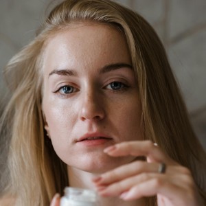 Woman With Blonde Hair Holding Cream Container