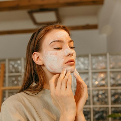 Beautiful Woman applying Skin Care Product on her Face