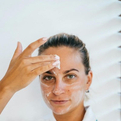A Woman Applying Facial Cream on Face
