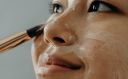 A Close-up Shot of a Woman Applying a Cream on