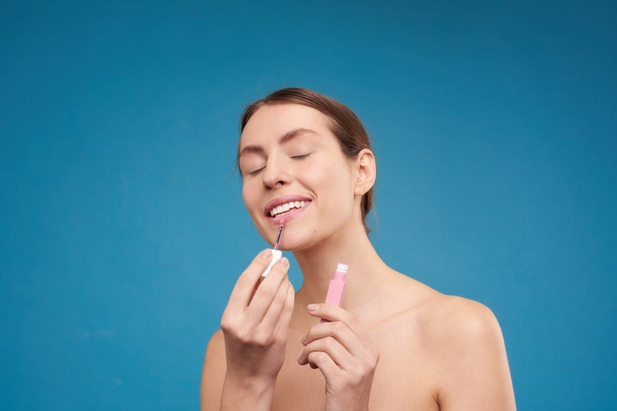 girl applying lip gloss