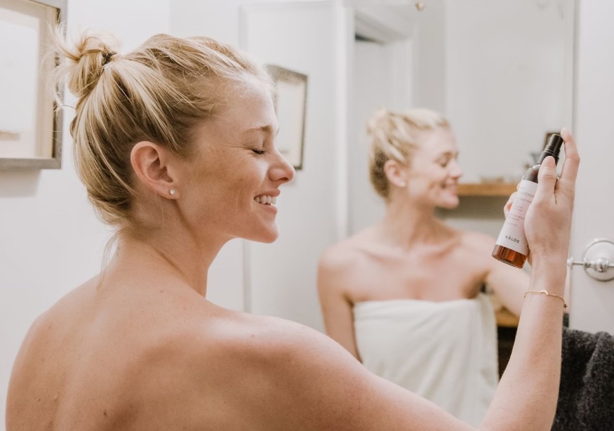woman spraying skincare product