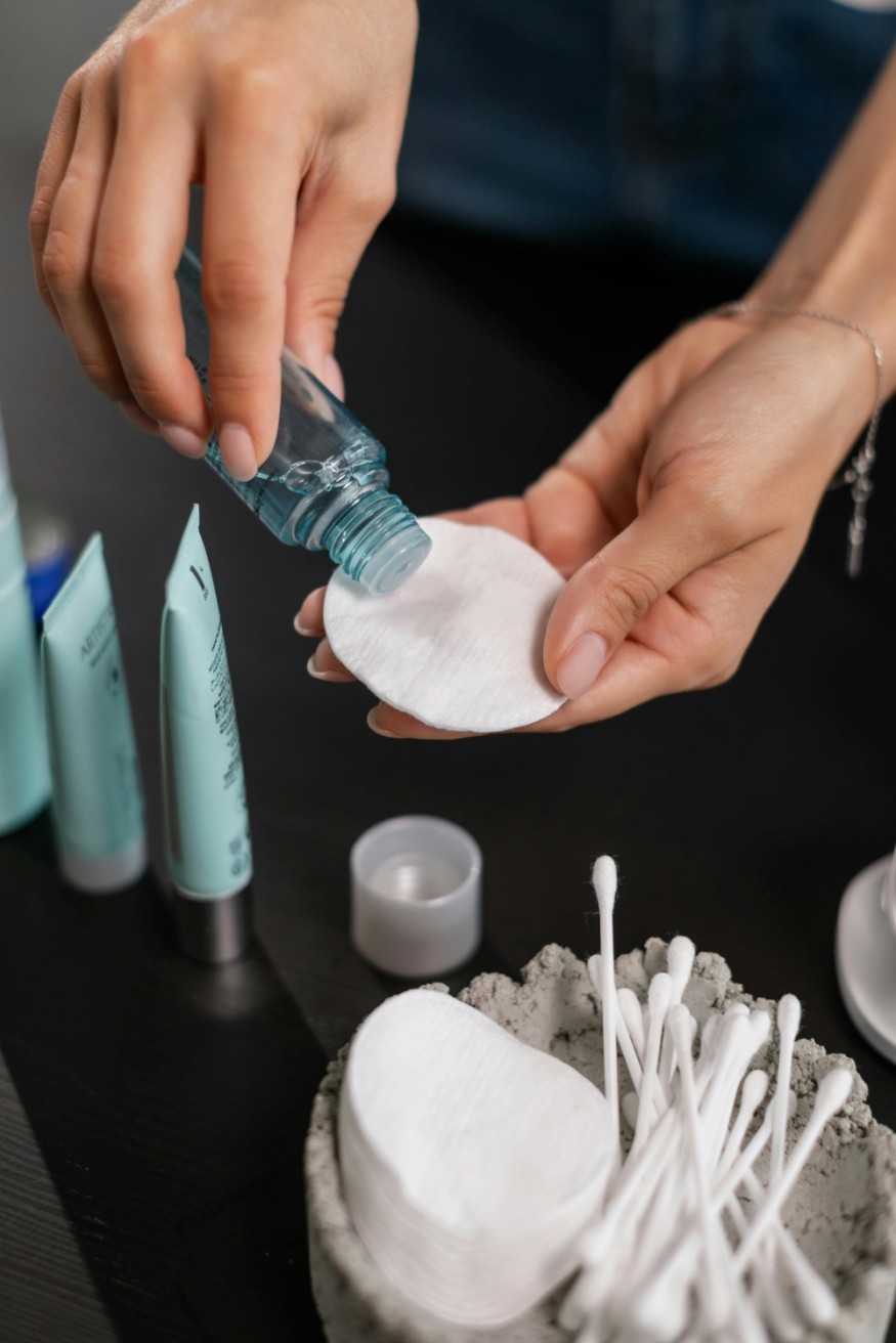 tan person applying toner to pad