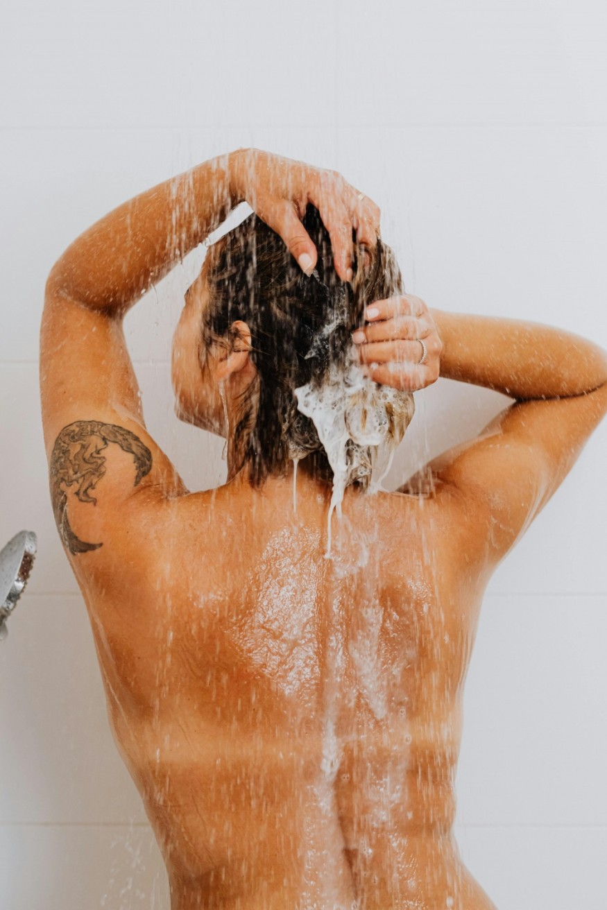 tan woman shampooing hair