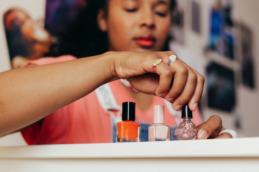 woman holding and opening nail polish