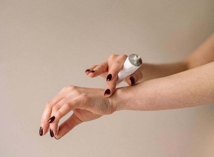 girl with nail polish applying cream